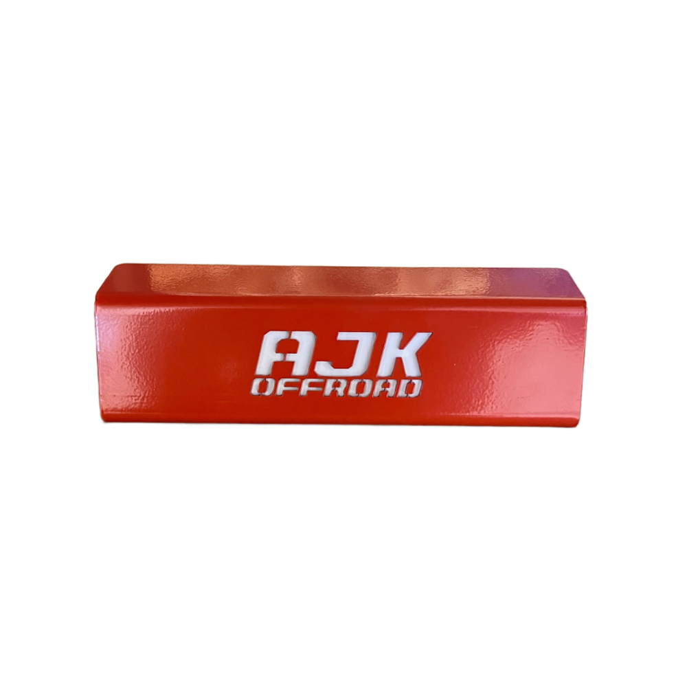 The Honda Talon Foot Rest from AJK Offroad is a red metal rectangle with AJK OFFROAD text in white, crafted via CNC laser cutting for precision and durability. It serves as a throttle control bracket for off-road enthusiasts, showcased on a white background.